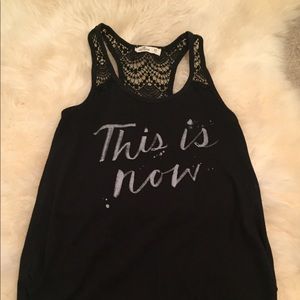 black lace back tank top with “this is now”